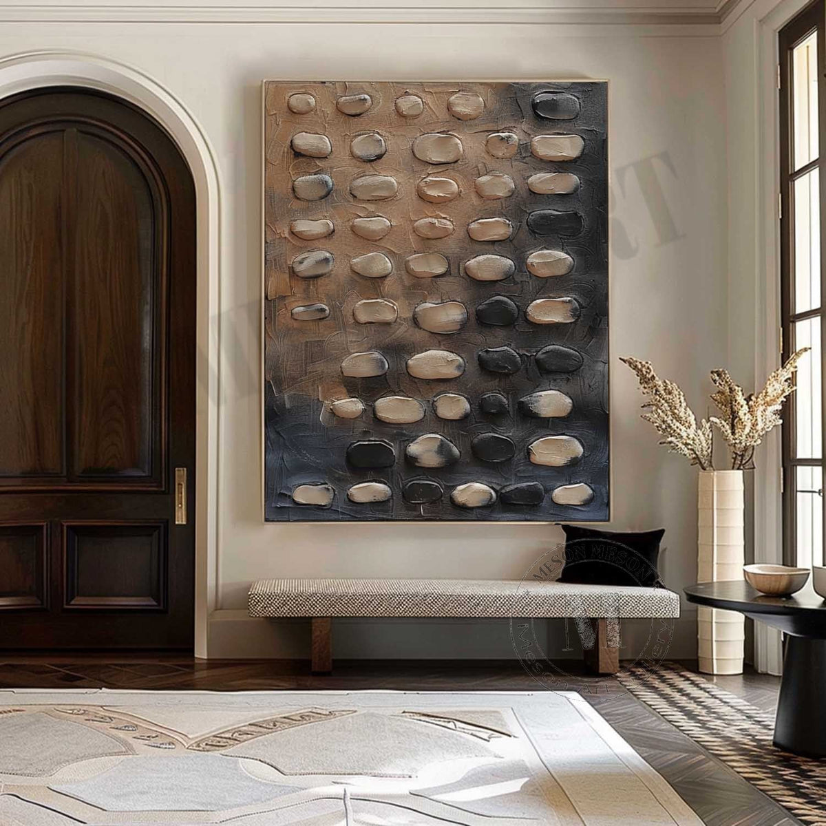Rounded beige and charcoal pebble-like forms beside an arched door