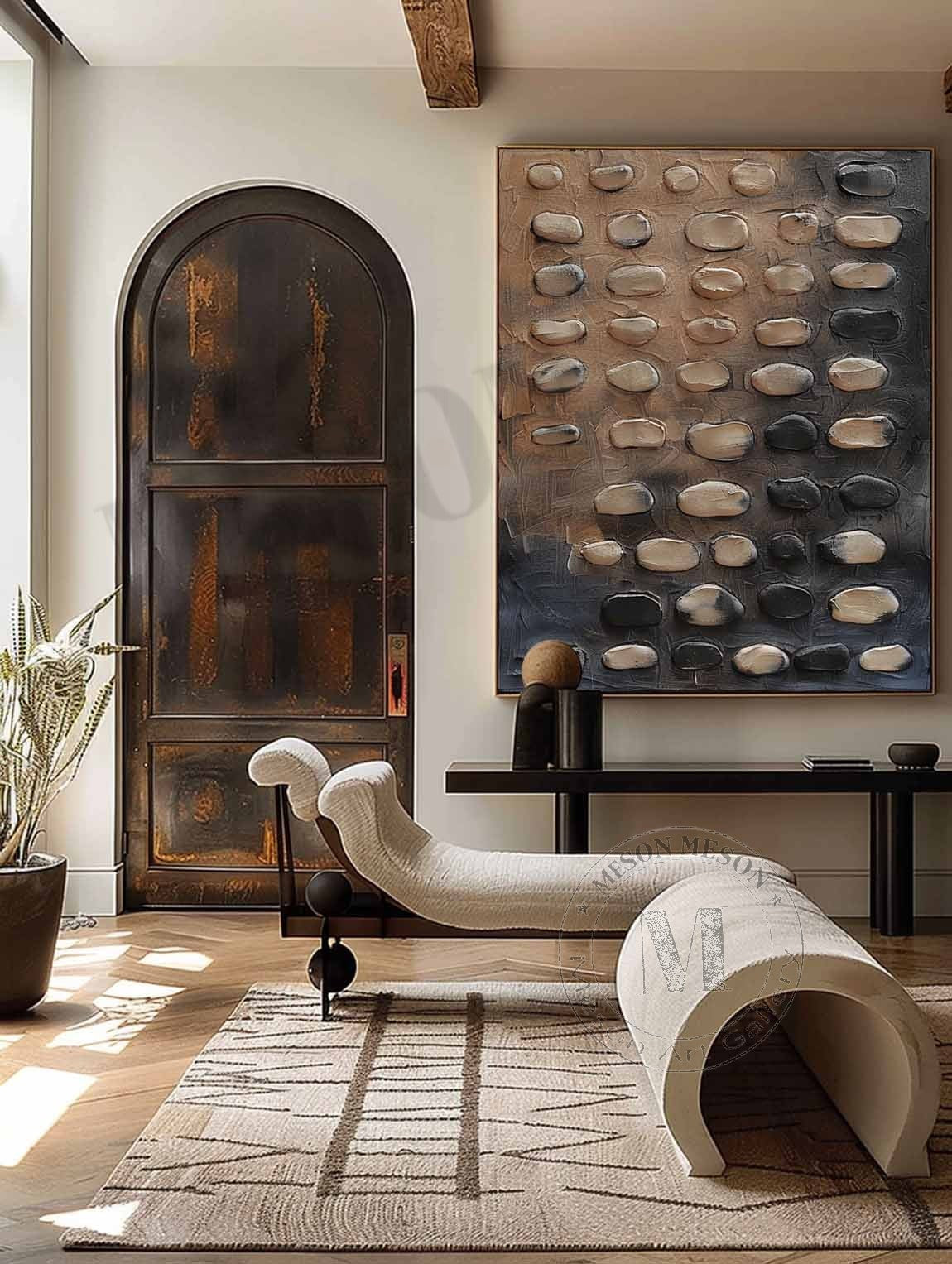 Rounded beige and charcoal pebble-like forms above a curved chair