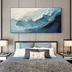A crashing blue wave with broad white foam above a bed