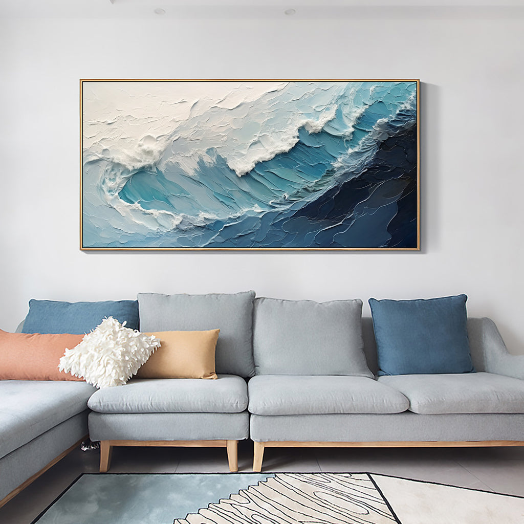 A crashing blue wave with broad white foam above a light blue sofa