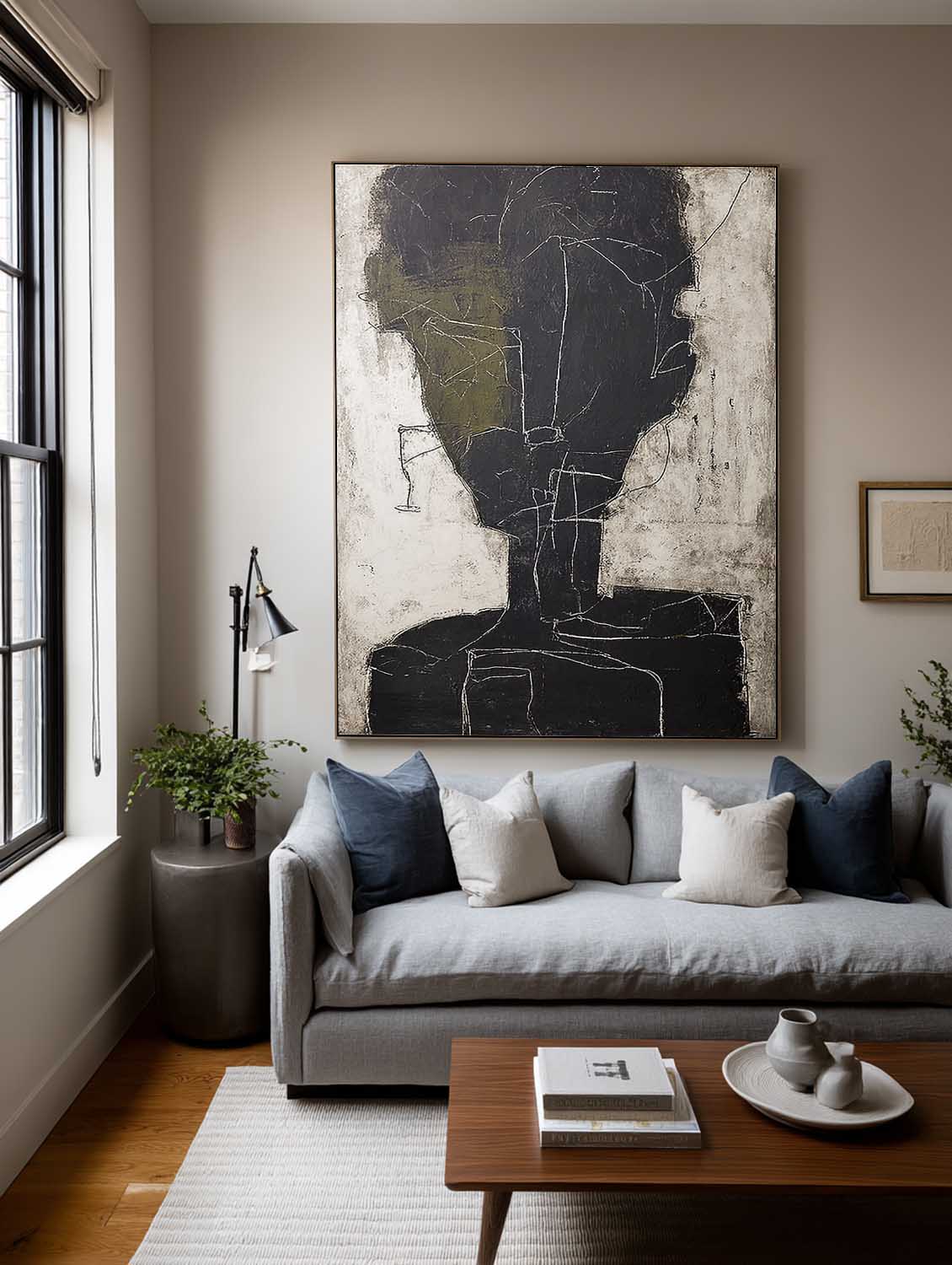An abstract charcoal face outline with an olive accent in a living room