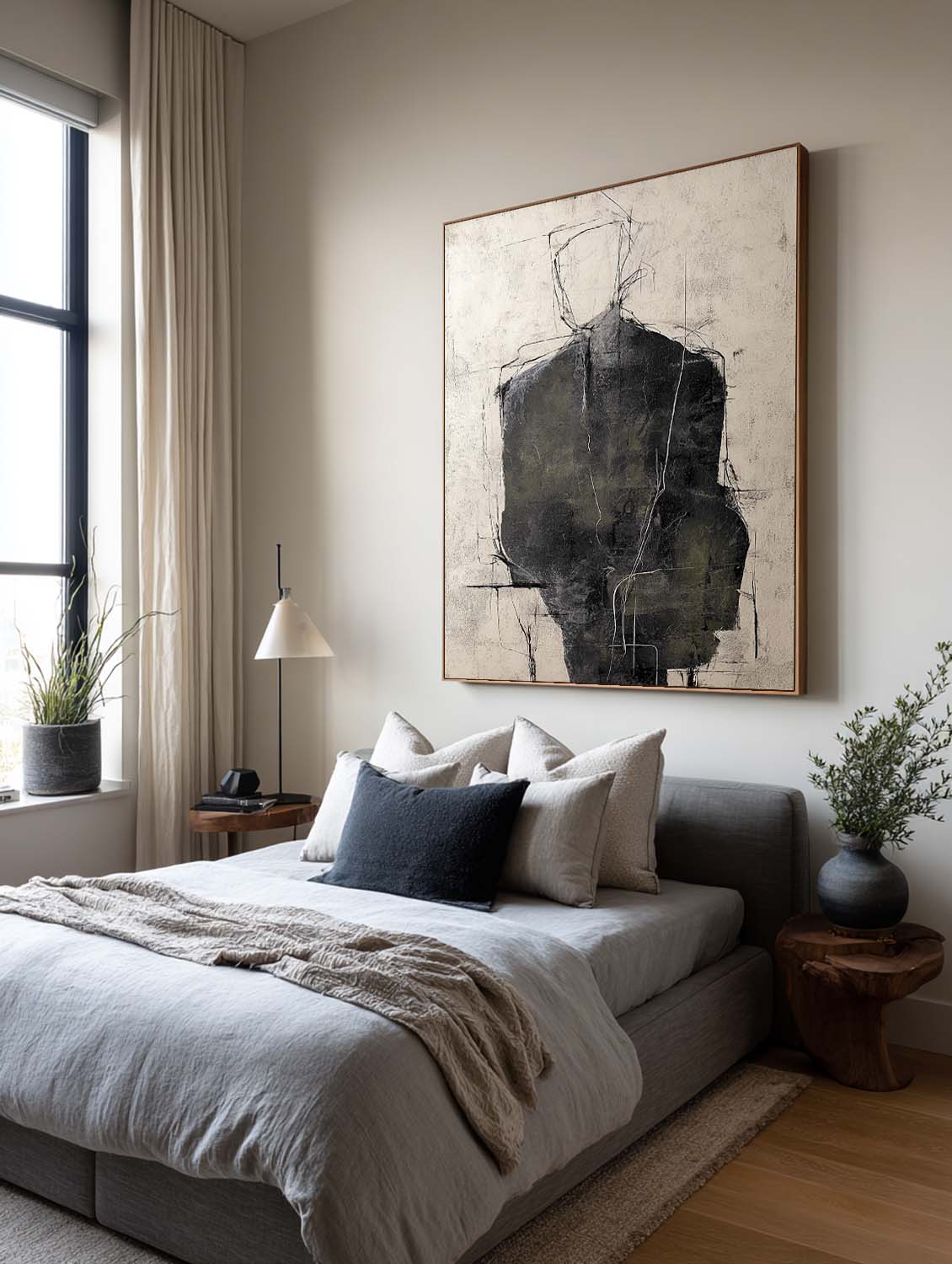 A charcoal figure with a fine outlined head on beige above a bed