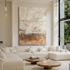 Cream and rust layered abstract fields above a pale sofa