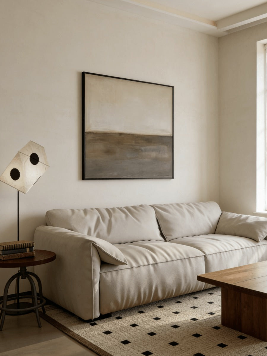 Cream and brown abstract painting above a sofa
